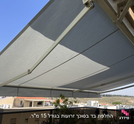 סוכך בד אפור עם זרועות מתכת על מרפסת
